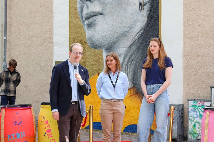 Kommunstyrelsens ordförande Robin Holmberg, Karin Bengtsson och Isabella Haak vid muralmålningen. Foto: Peter Jakobsson