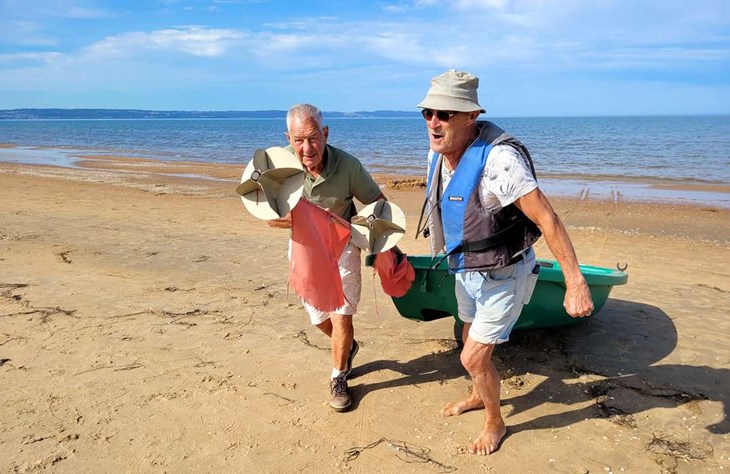 Beslutsamt drar Ingvar Nilsson och Christer Hansson upp båten på stranden. De vitala 80-plussarna har fiskat i Laholmsbukten sedan 1950- och 1960-talet och känner havet utan och innan. Foto: RIckard Gustafsson