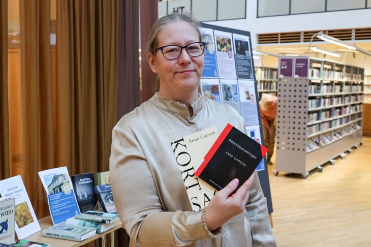 Bibliotekarie Maria Bengtsson med några av Anne Carsons verk. Foto: Peter Jakobsson